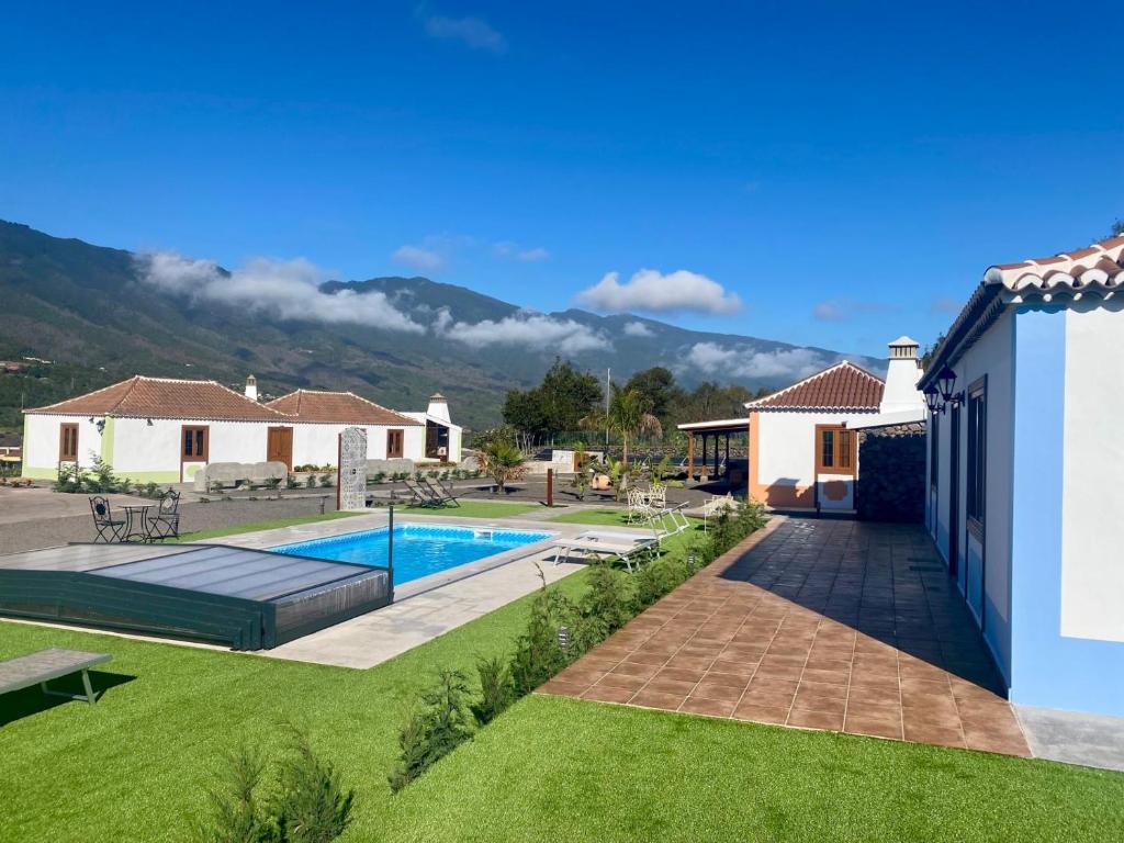 a villa with a swimming pool and mountains in the background at Villas Morera in Breña Baja