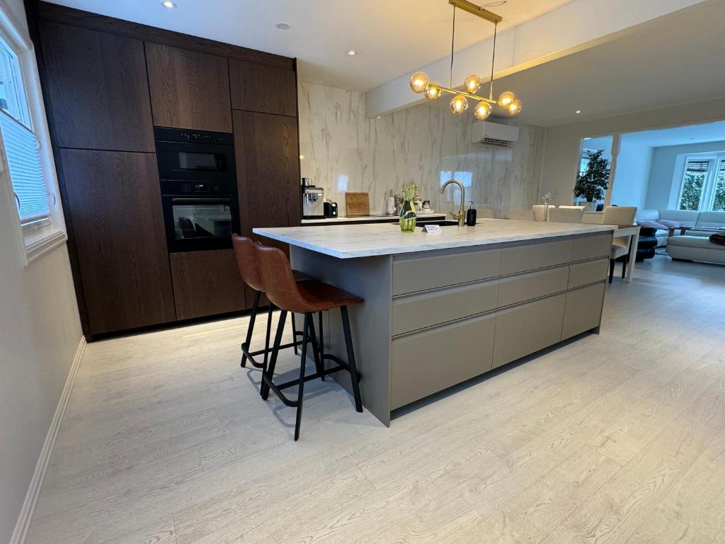 a kitchen with a large island in the middle of a room at Just Like Home Bed & Spa Porsgrunn in Porsgrunn
