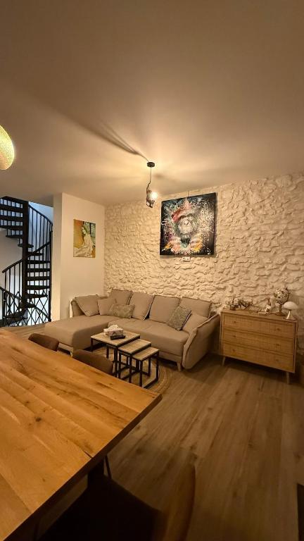 un salon avec un canapé et un mur de briques dans l'établissement Maison cosy au cœur d'Étaples sur mer, à Étaples