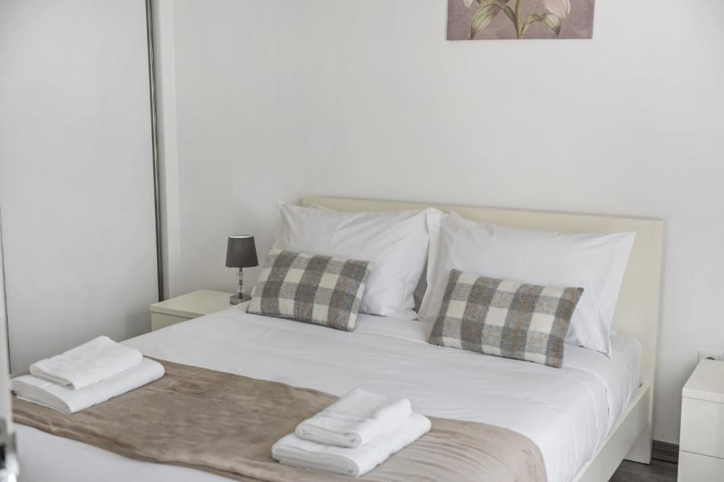 a white bed with two folded towels on it at Seaside Charm II in Câmara de Lobos