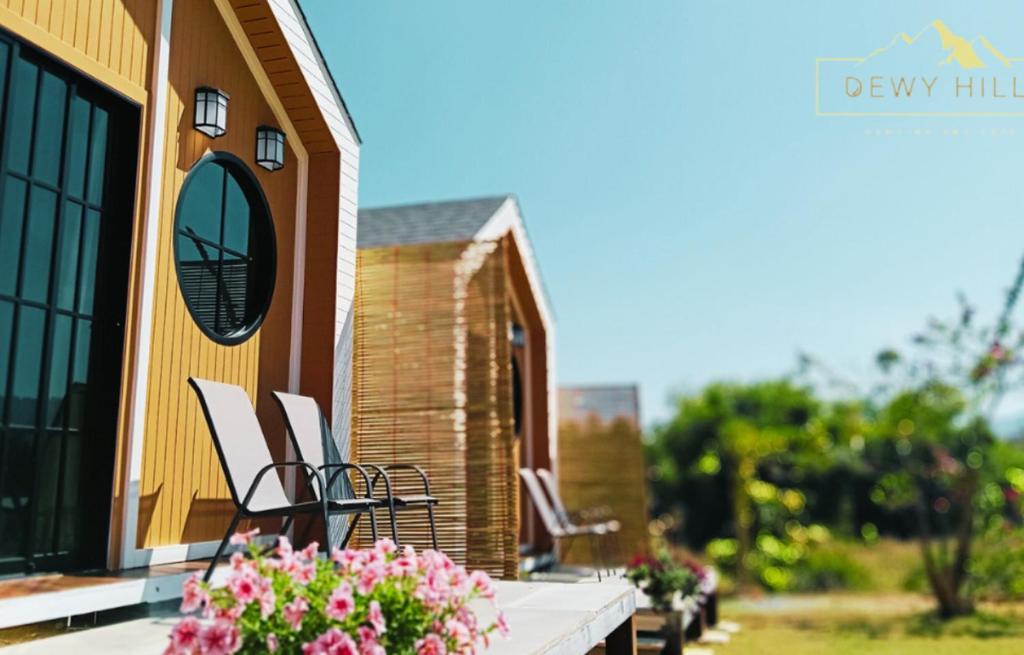 una veranda con sedie e fiori su una casa di Dewy Hill ดิวอี้ ฮิลล์ เขาใหญ่ วังน้ำเขียว a Ban Khlong Krathon