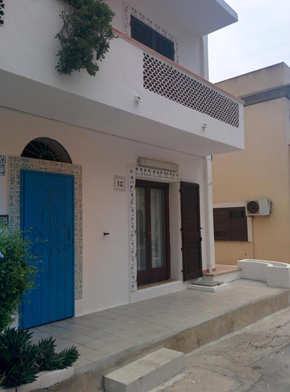 a white house with a blue door and stairs at Doria 18 in Lampedusa