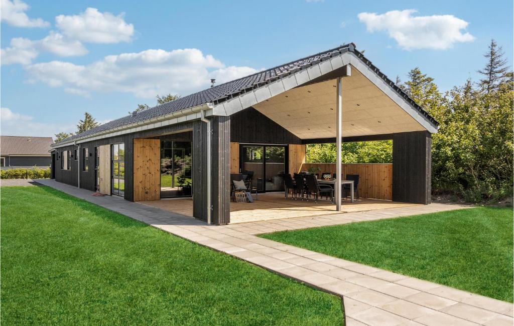 a wooden pavilion with a patio and green grass at Cozy Home In Tarm With Sauna in Tarm