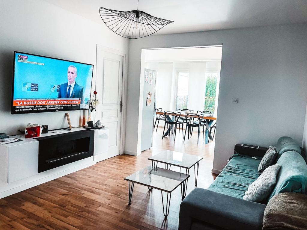 un salon avec un canapé et une télévision à écran plat dans l'établissement Charmant cottage bord de mer camping 4 etoiles, à Hermanville-sur-Mer