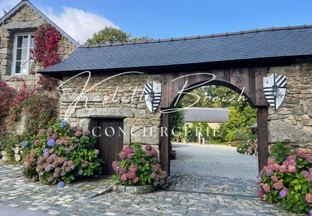 a stone entrance to a wedding venue with flowers at La familiale du manoir de Kerollivier in Saint-Gilles-Pligeaux