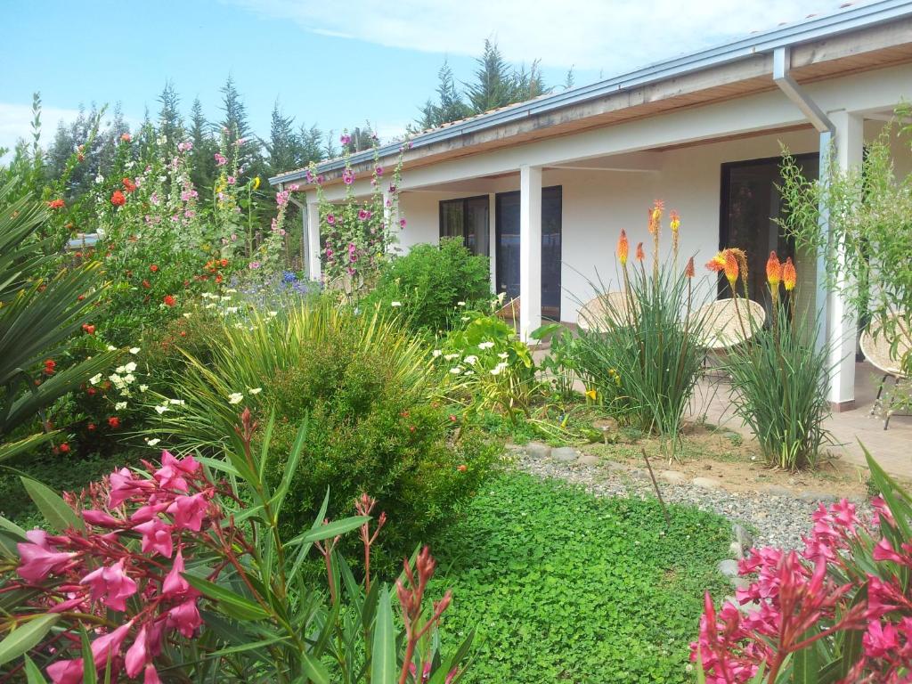 a garden in front of a house with flowers at La Maravilla Lodge in Vilches