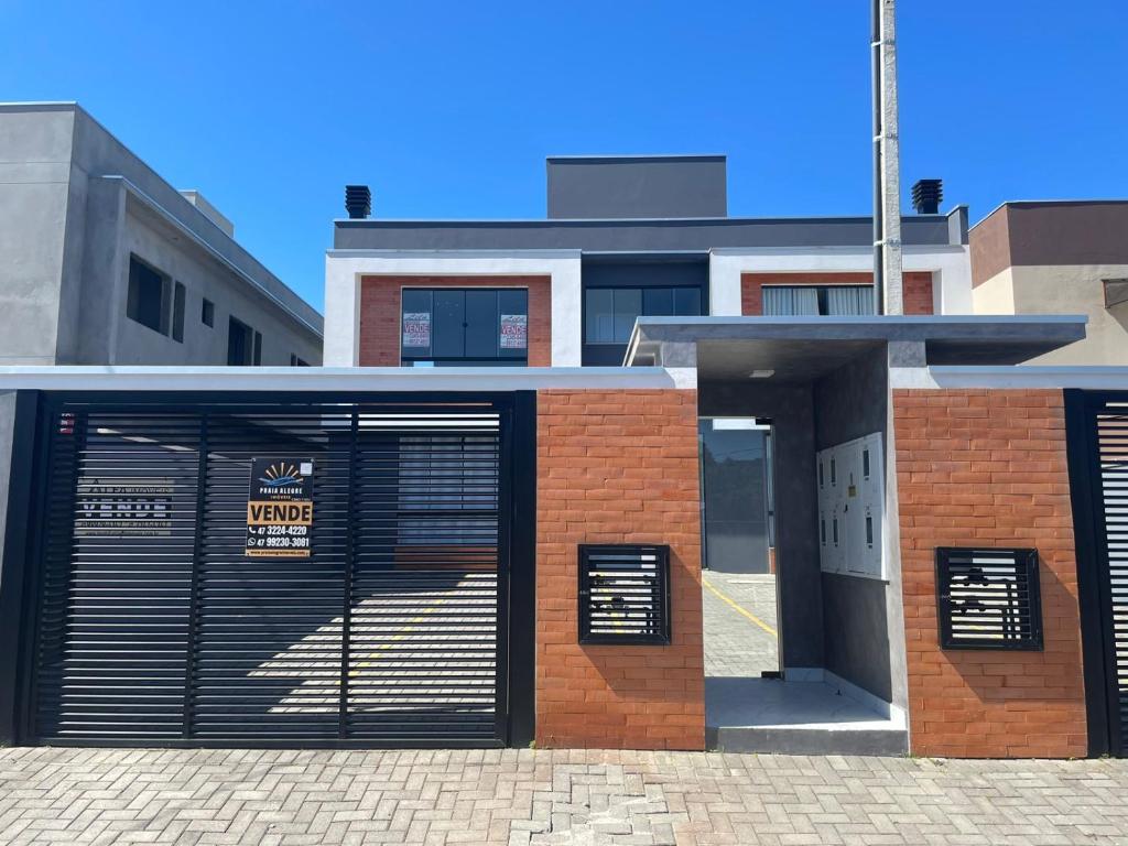 a building with two garage doors in front of it at Seu Lar Temporário in Penha