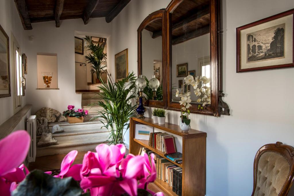 パレルモにあるDimora Torremuzzaのピンクの花と鏡が飾られたリビングルーム