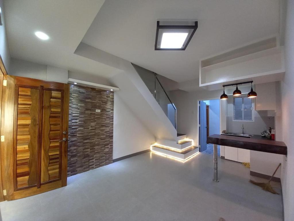 an attic room with a staircase and a brick wall at Quiin Home cozy modern house in Pampang
