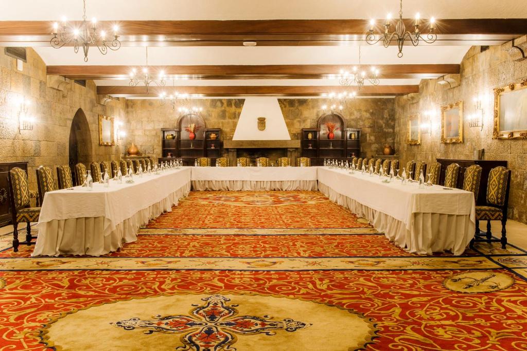 a banquet hall with tables and chairs in a room at Hotel Fortaleza do Guincho Relais & Châteaux in Cascais