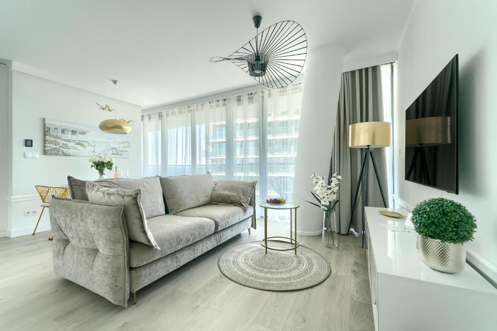 Una sala de estar con un sofá y un televisor. en Your Holidays Waves D648 z widokiem na morze, en Międzyzdroje