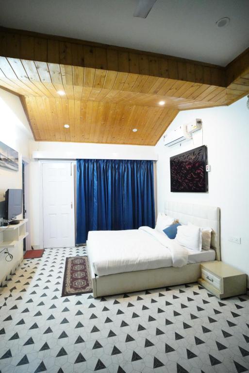 een slaapkamer met een groot bed en een blauw gordijn bij The Castle Villa Pine View Kasauli in Kasauli