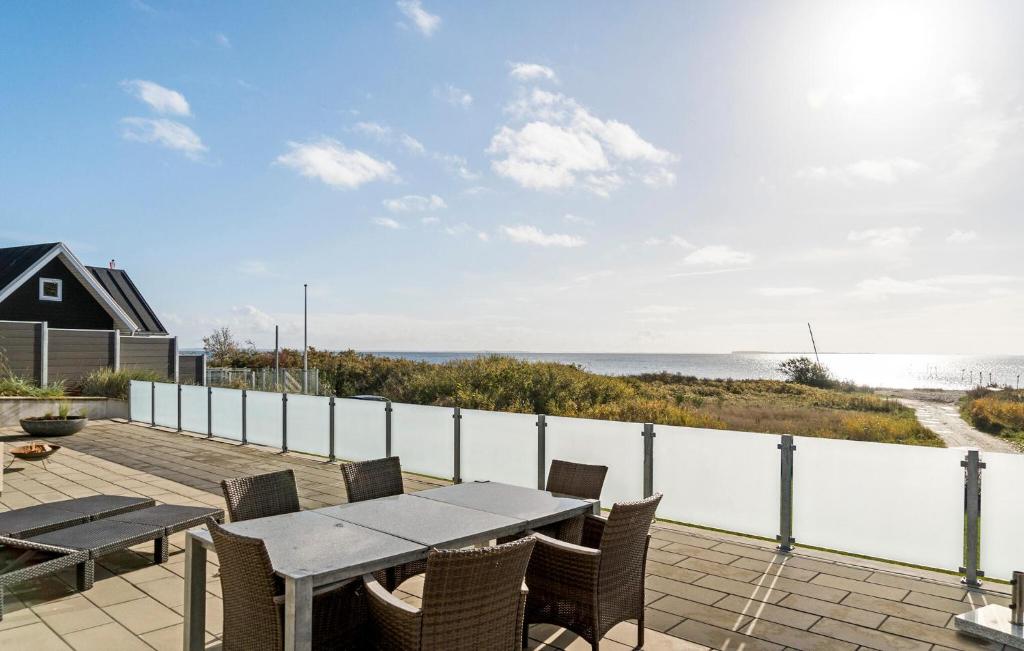 a patio with a table and chairs and the ocean at 2 Bedroom Cozy Home In Bjert in Bjert Strand