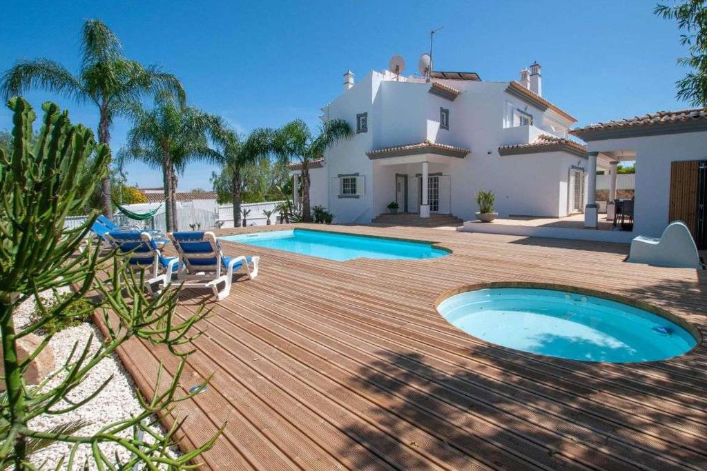 Un patio trasero con piscina y una casa. en Villa Perla by Vintage Travel, en Guia