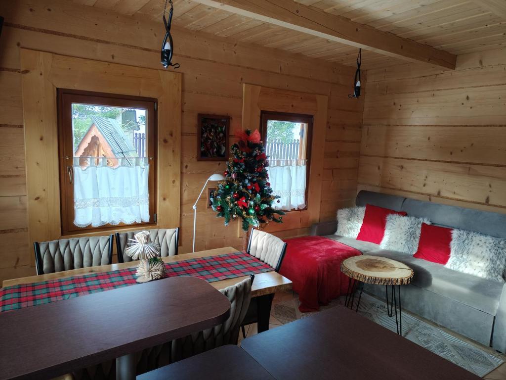 a living room with a christmas tree in a log cabin at Widokowe Domki Kościelisko in Kościelisko