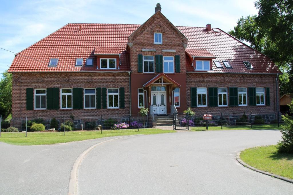una gran casa de ladrillo con techo rojo en Das Landhaus Wohnung 2, en Kirch Mulsow