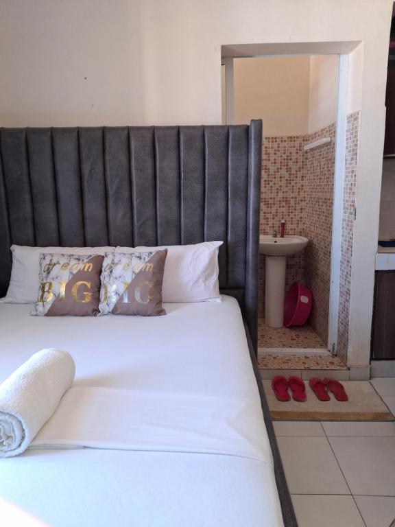 1 cama con cabecero negro en un dormitorio en midenlavin studio Airbnb, en Mombasa