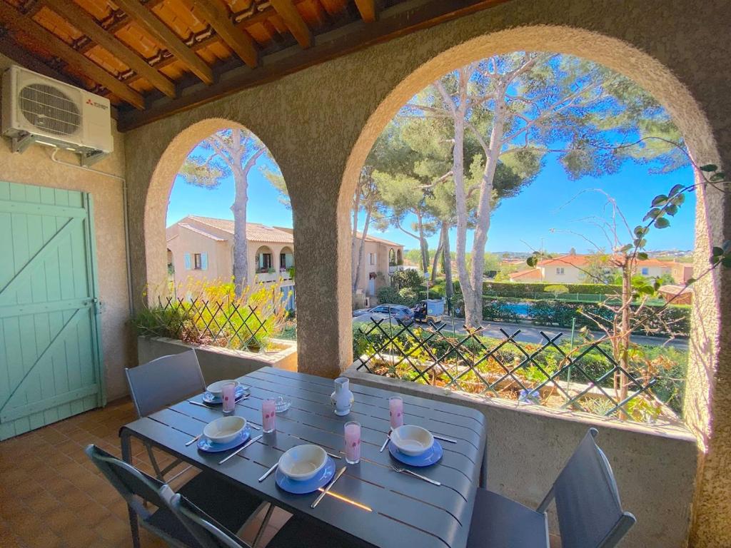 une table bleue avec des chaises sur une terrasse avec vue dans l'établissement T4 dans résidence avec piscine, à Six-Fours-les-Plages