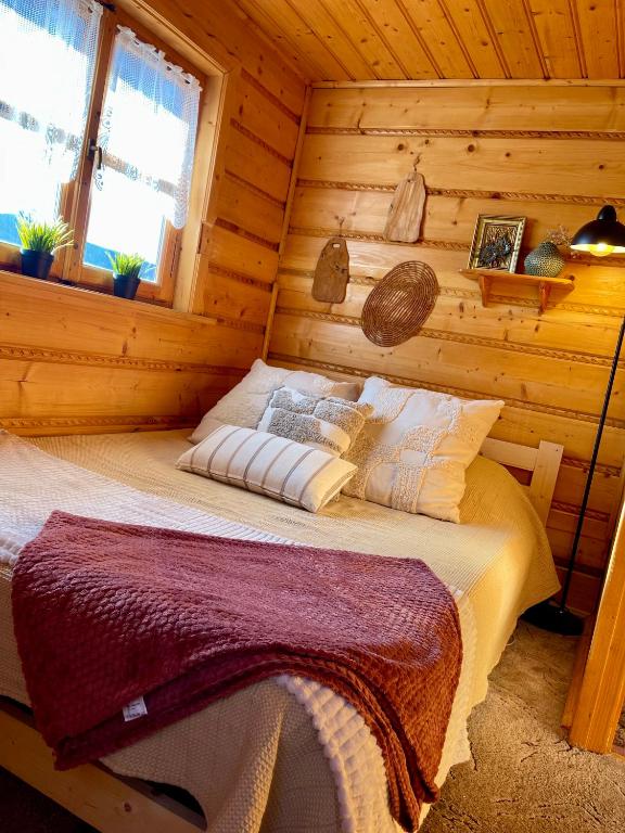 a bedroom with a bed in a log cabin at PEŁNA CHATA w Gródku nad Dunajcem in Gródek Nad Dunajcem
