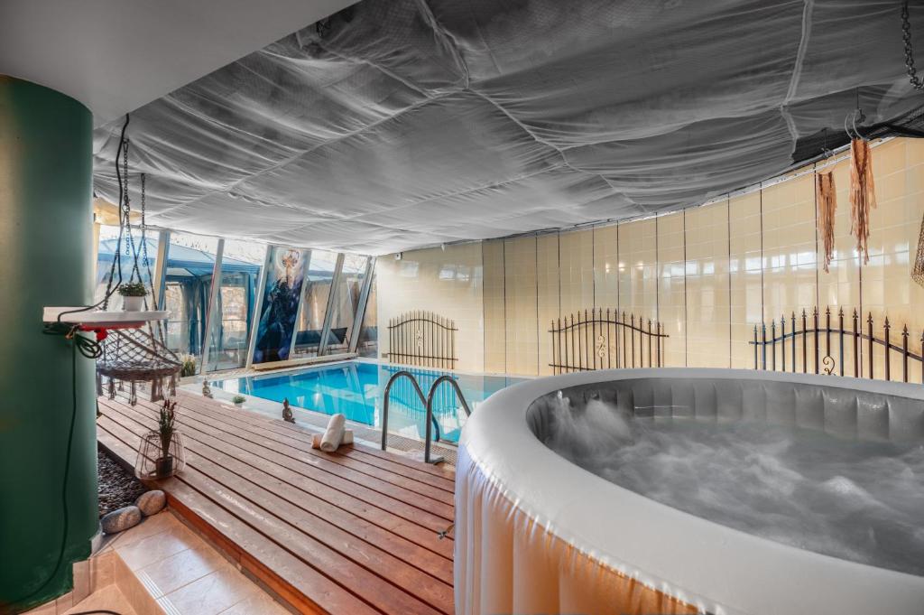 Una bañera grande en una habitación con piscina. en Unique apartment with private pool, cinema, SPA, en Praga