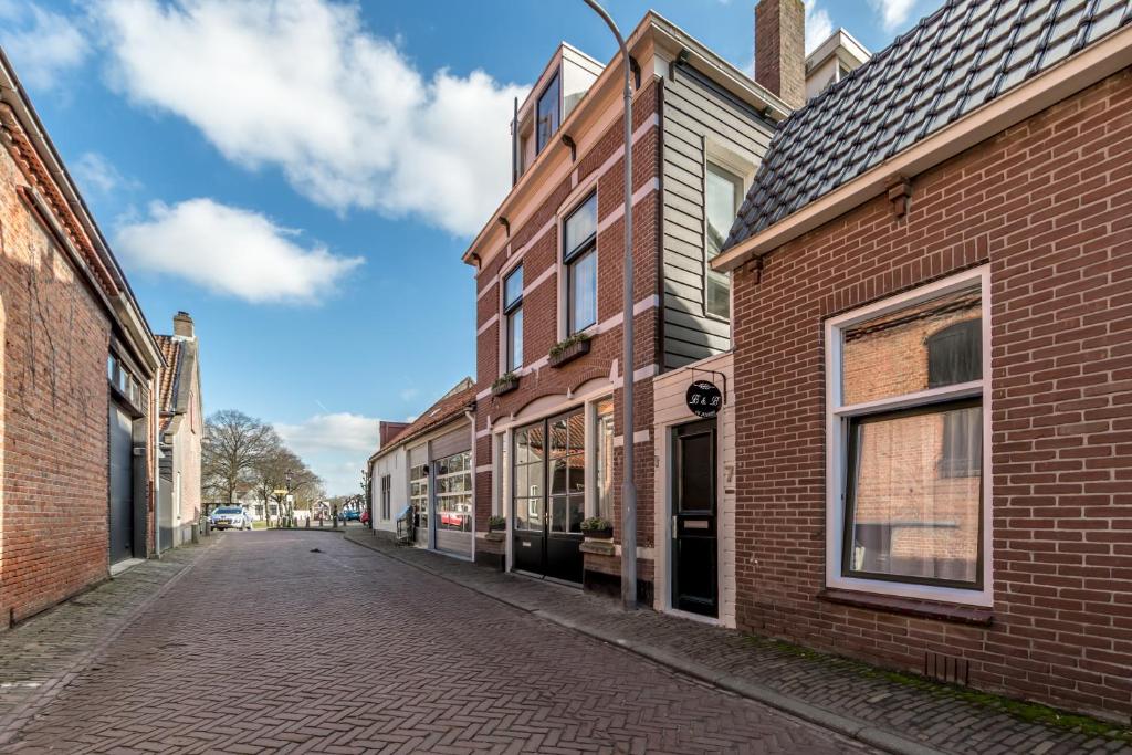 an empty street in an old town with brick buildings at Studio Even dur Uut in Noordgouwe