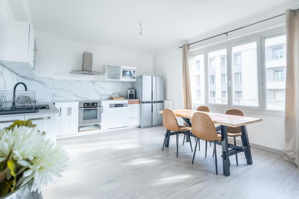 une cuisine avec une table et des chaises en bois dans l'établissement A deux pas du Vel'odrome, à Marseille