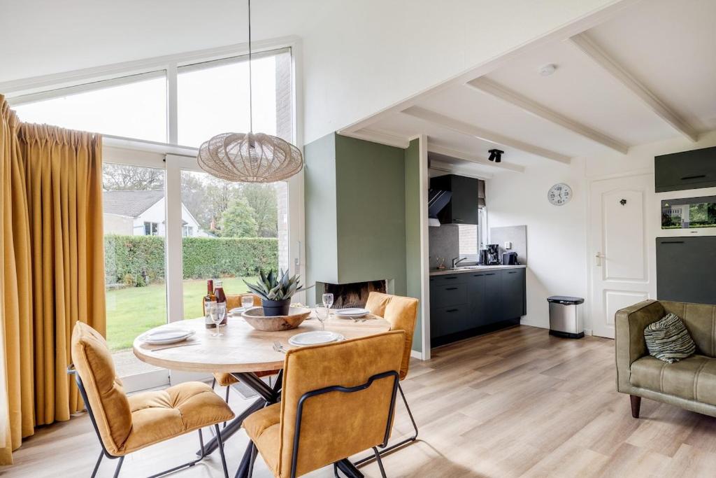 a kitchen and dining room with a table and chairs at Blauwreiger I Geniet in dit Moderne Huisje in Zwiggelte