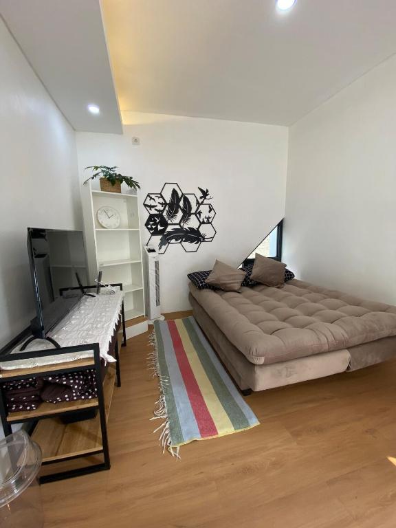 - un salon avec un grand canapé et un tapis dans l'établissement CorriDoor Daily Homestay, à Bandung