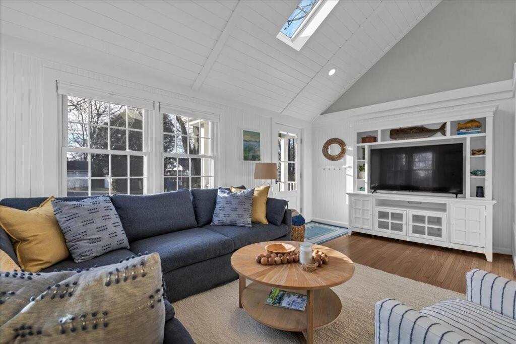 a living room with a blue couch and a table at Sea Glass Cottage-in the heart of Clinton Harbor! in Clinton