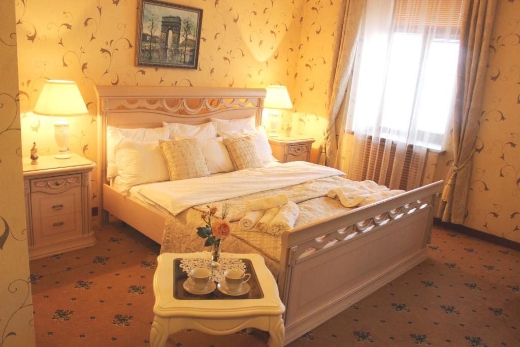 a bedroom with a bed and a window and a table at Hotel Lux Angliter in Vologda