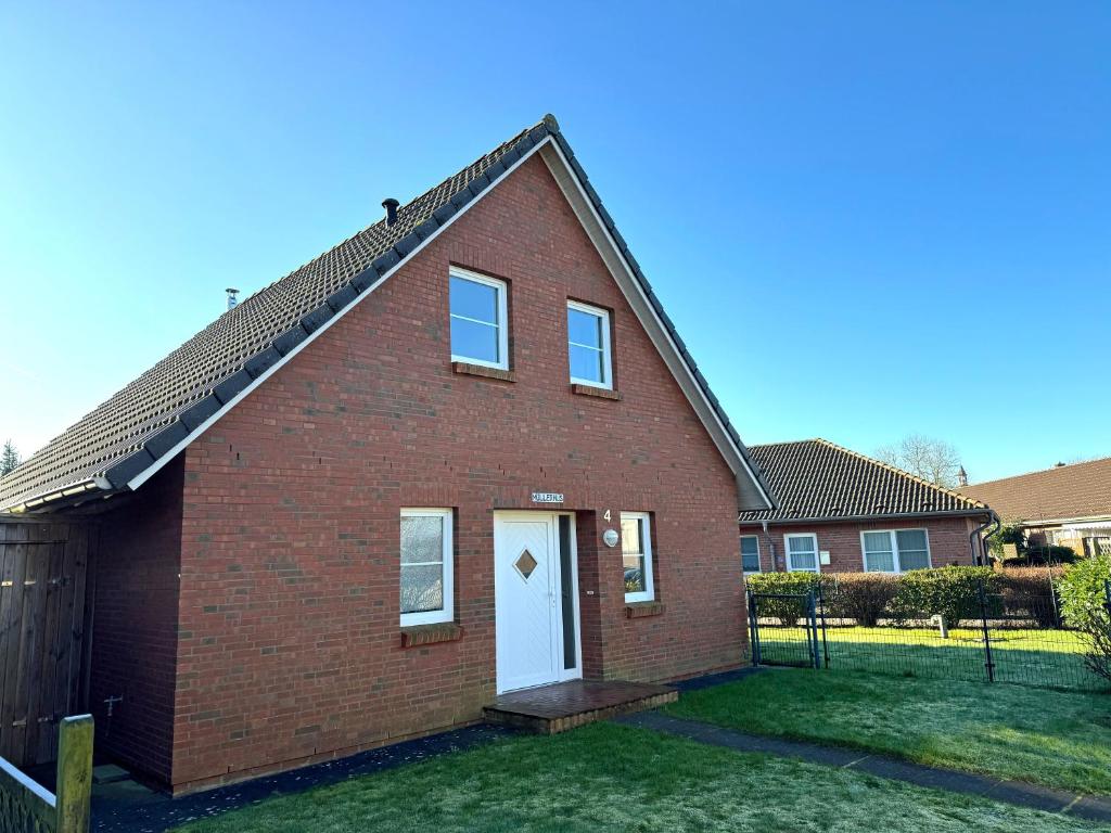 a red brick house with a white door at Mullerhuus in Nordstrand