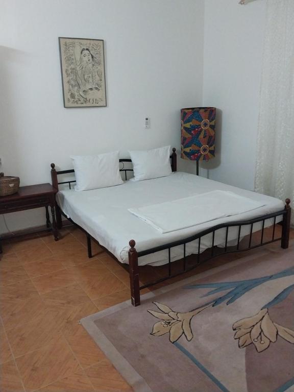 a bedroom with a bed in a room with a table at Chez Ousmane Fall ASECNA Bis in Saint-Louis