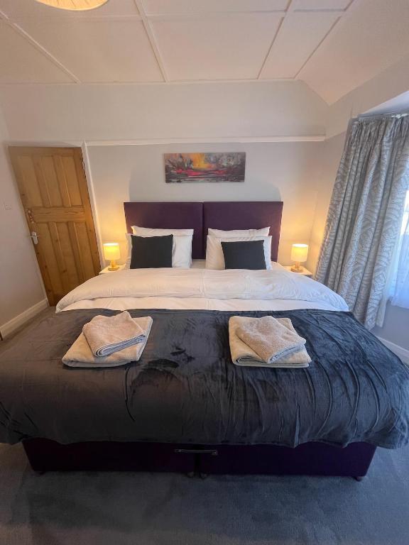 a bedroom with a large bed with two towels on it at The Grenadine House in South Norwood