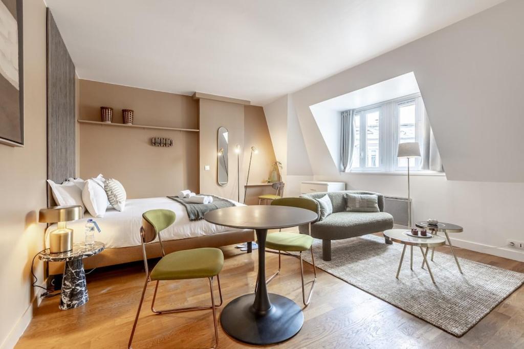 une chambre avec un lit, une table et des chaises dans l'établissement Arc de Triomphe - 2 people, à Paris