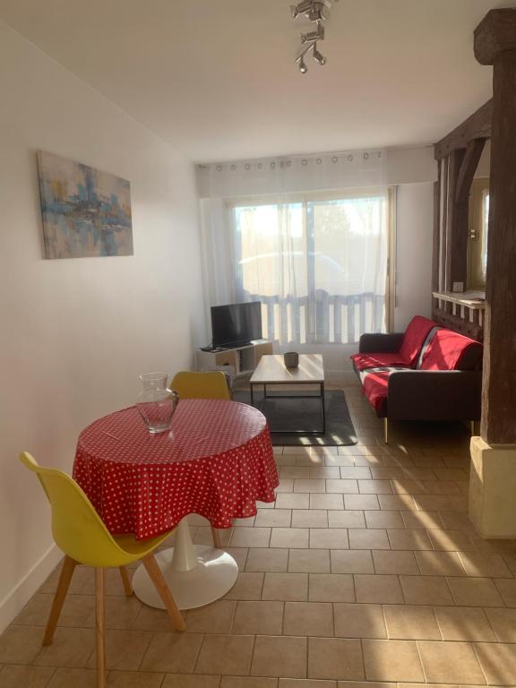 - un salon avec une table rouge et des chaises jaunes dans l'établissement Studio Kennedy, à Trouville-sur-Mer