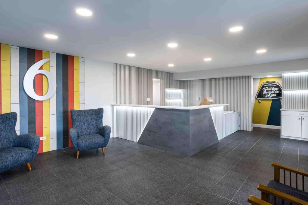 a lobby with two chairs and a counter in a room at Motel 6 Hickory NC in Hickory