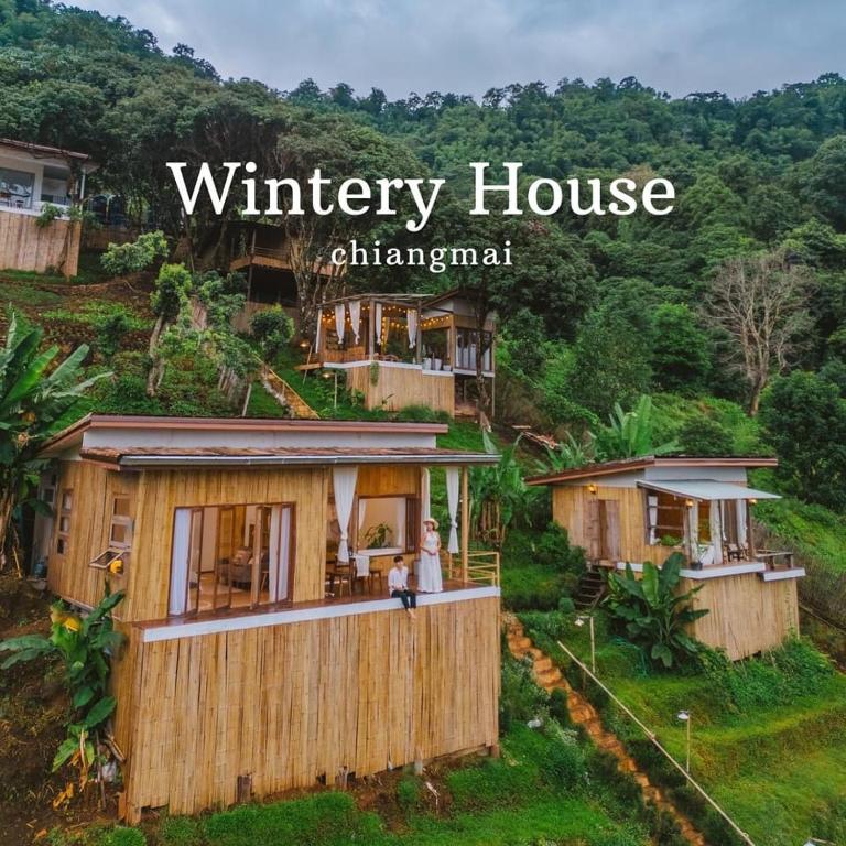 a woman standing on the balcony of a wooden house at Wintery House in Ban Thung Phan Ha