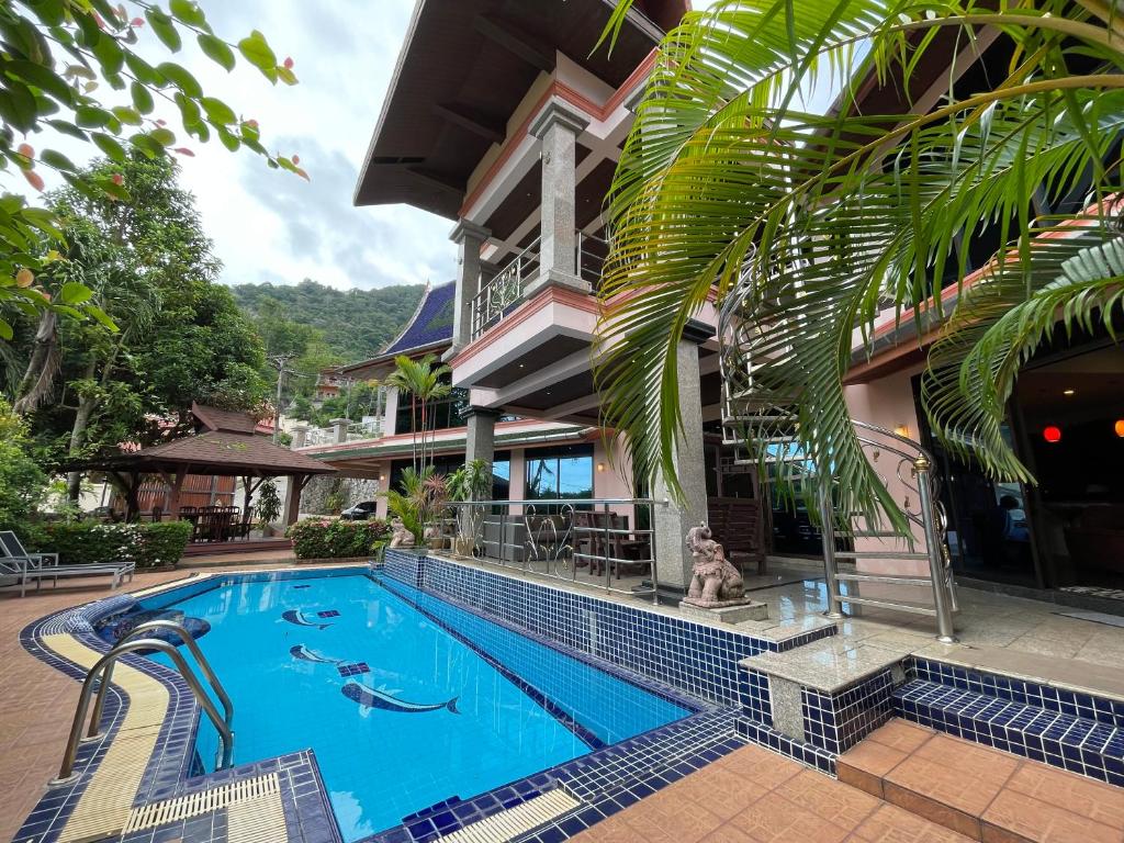 a resort swimming pool in front of a building at Вилла в сердце Пхукета in Ban Lum Fuang
