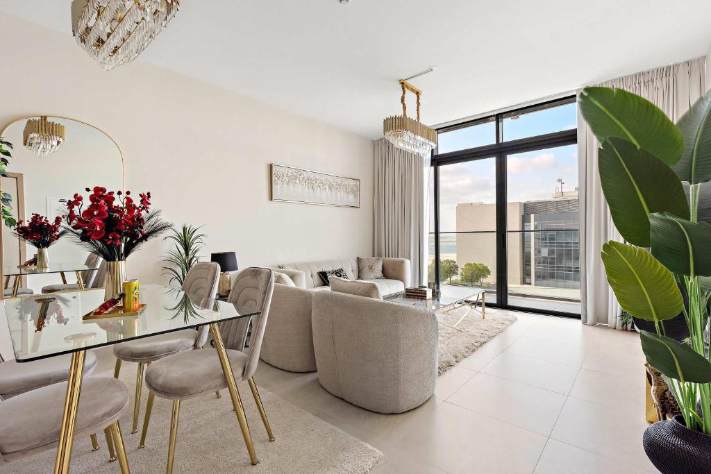 a living room with a table and chairs at Silkhaus Premium 1BR at Soho Square in Saadiyat in Abu Dhabi