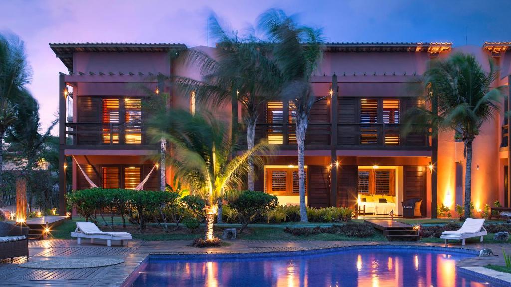 a house with a swimming pool in front of a building at Naquela Jericoacoara in Jericoacoara