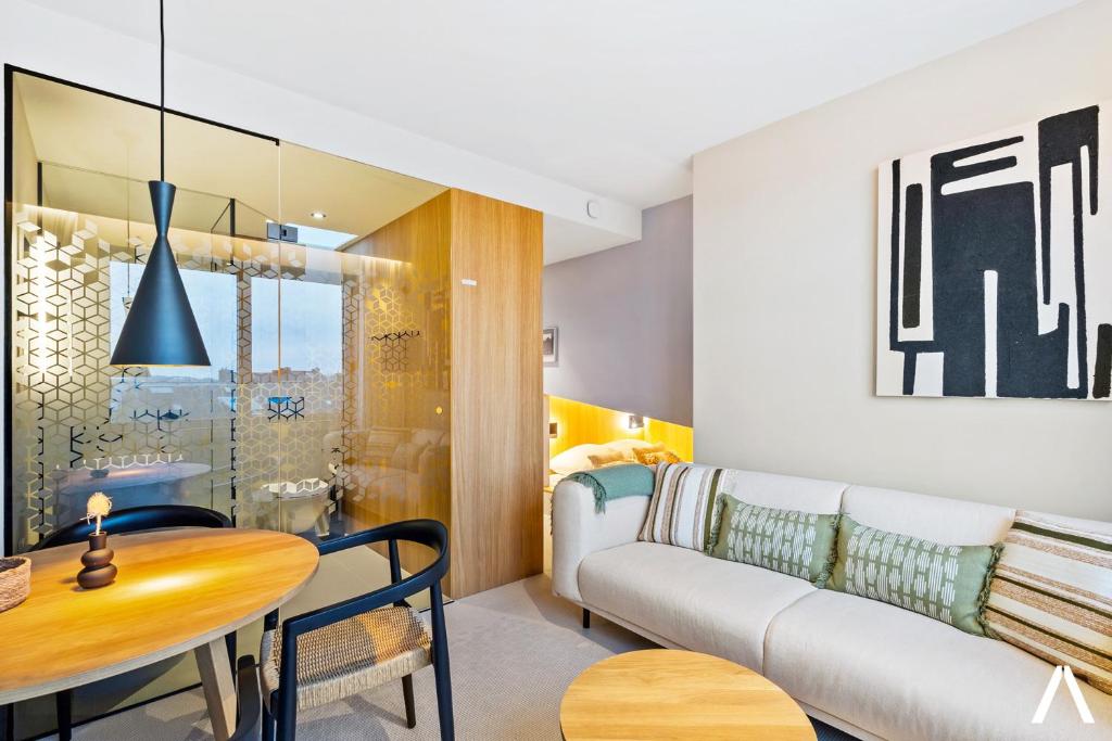 a living room with a couch and a table at Modern and Cozy Studio Retreat near the City in Luxembourg