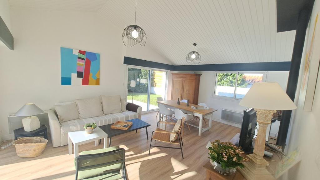 un salon avec un canapé et une table dans l'établissement LES MUGUETS - Maison 4 chambres à 600m de la plage, à Saint-Hilaire-de-Riez