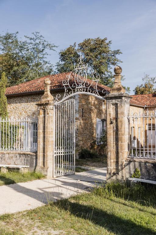 un ancien bâtiment en briques avec un portail dans l'herbe dans l'établissement Campagne Muller, à Uchacq-et-Parentis