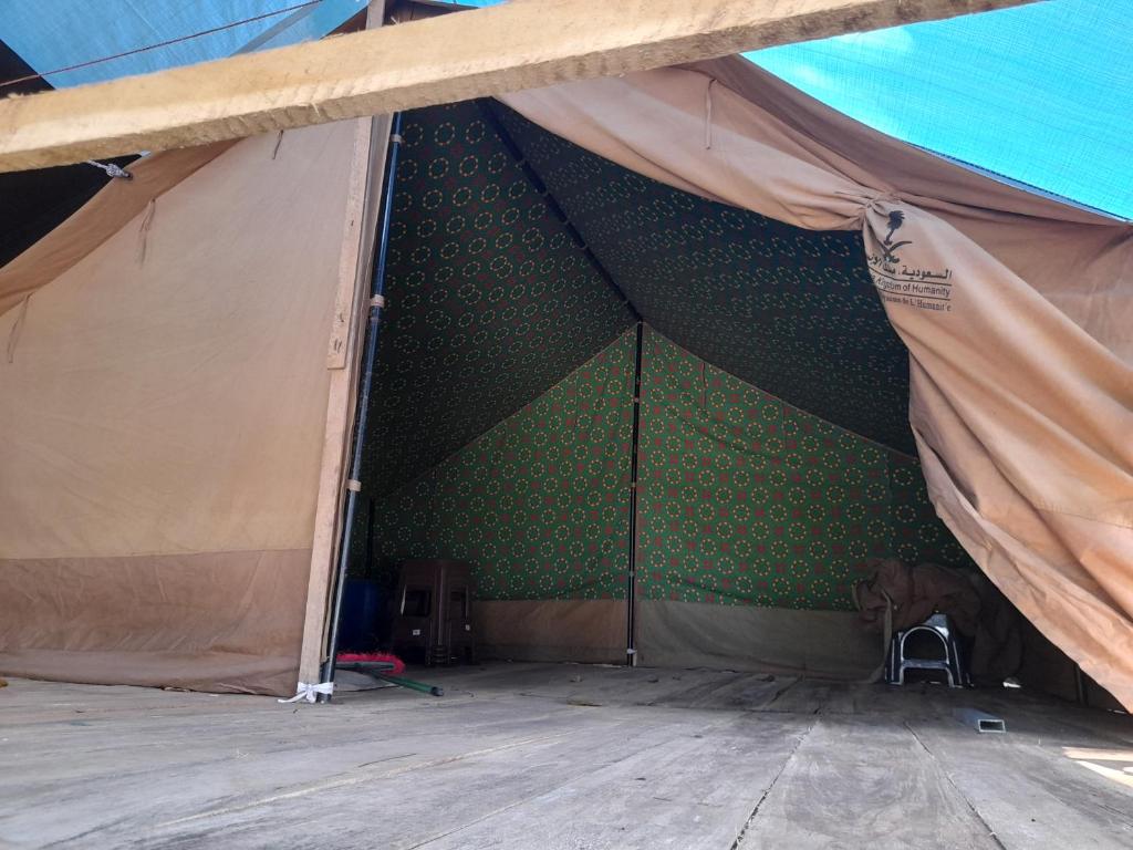 a tent with a green wall and a wooden floor at Rustic Campsite Kalutara South in Kalutara