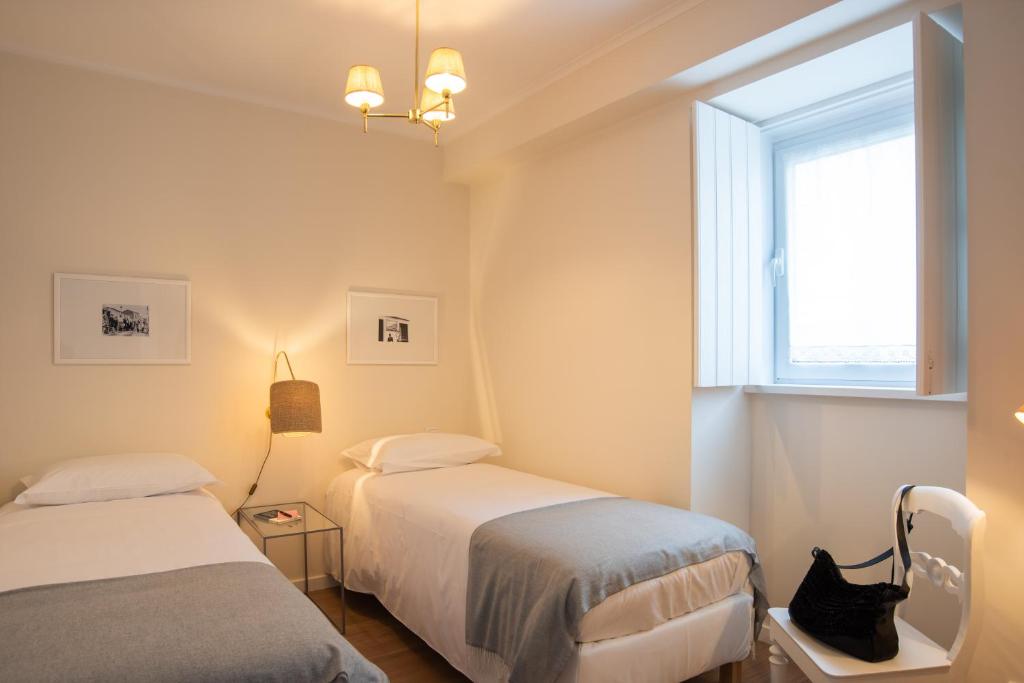 zwei Betten in einem kleinen Zimmer mit Fenster in der Unterkunft Vila Marta - Canário da Terra in Vila Franca do Campo