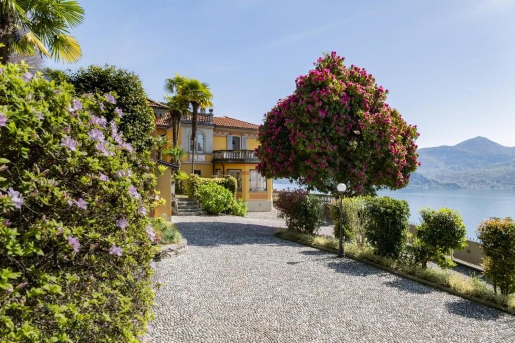 a garden with flowers and a building next to the water at Villa Bruna in Ghiffa