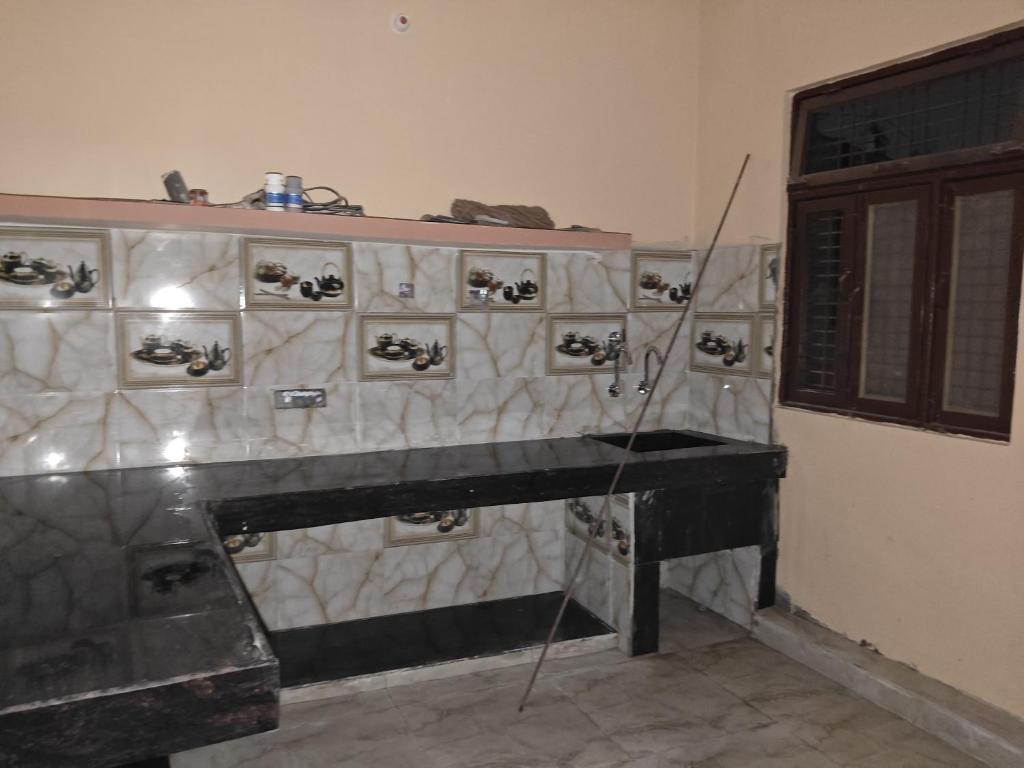un piano negro en una habitación con pared en Sangam bhawan, en Prayagraj