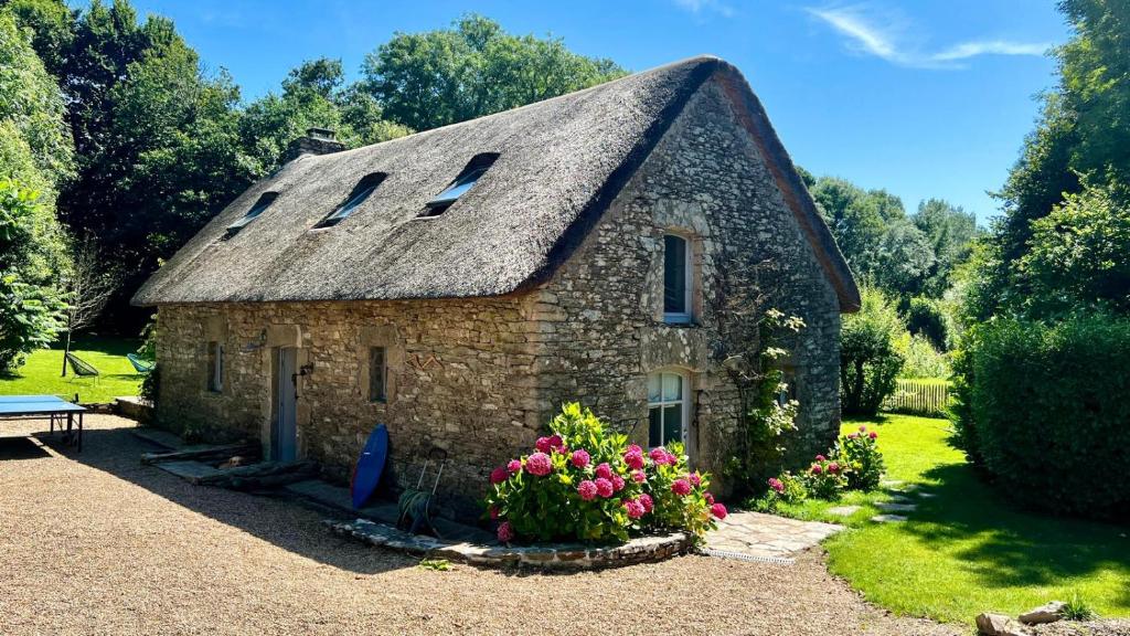 Cette petite maison en pierre est dotée d'un toit de chaume. dans l'établissement Chaumière bord de mer, à Keranquernat