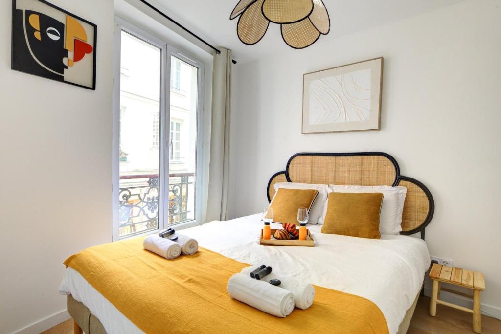 une chambre avec un lit avec deux serviettes dessus dans l'établissement Suite Eastern appartement au cœur du Marais, à Paris