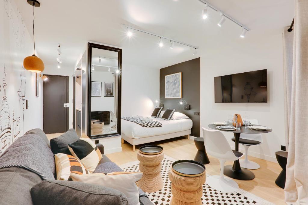 un salon avec un canapé et un lit dans l'établissement Au coeur du sacré coeur, à Paris